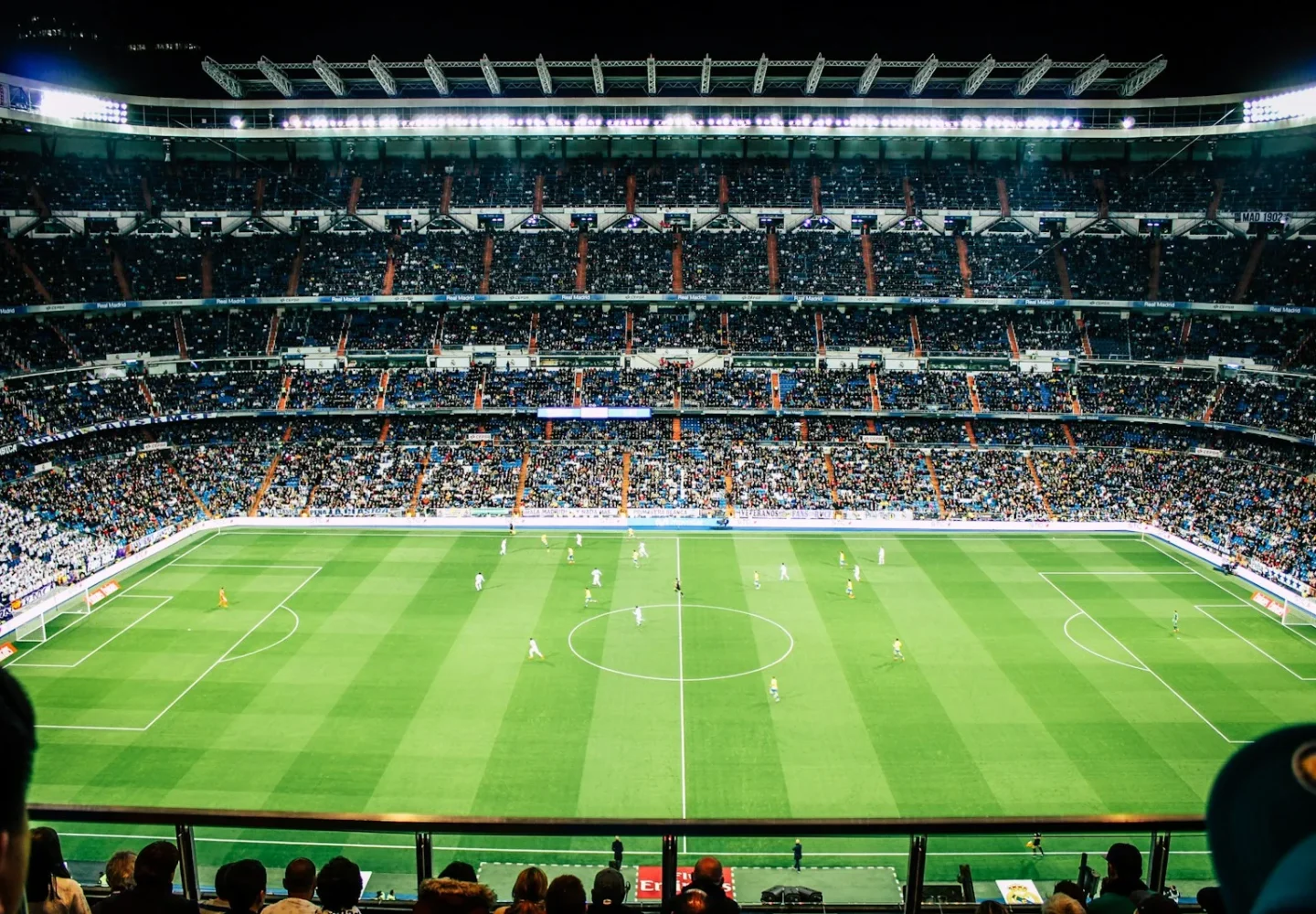 Estadio de fútbol iluminado con público en las gradas